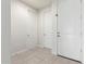 Clean hallway featuring tile flooring and multiple doors, enhancing the sense of space at 2235 W Park St, Phoenix, AZ 85041