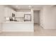 Well-lit kitchen with a breakfast bar, white cabinets, stainless steel appliances, and tile flooring at 2235 W Park St, Phoenix, AZ 85041
