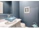 Stylish powder room featuring blue walls, modern vessel sink, and elegant decor at 2415 W Hazelhurst Ct, Anthem, AZ 85086