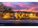 Inviting single-story home with desert landscaping, warm exterior lighting, and a colorful sunset sky at 2415 W Hazelhurst Ct, Anthem, AZ 85086