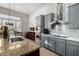 Modern kitchen with stainless steel appliances, granite countertops, gray cabinetry, and sleek vent hood at 2415 W Hazelhurst Ct, Anthem, AZ 85086