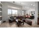 Comfortable living room featuring a plush brown sofa, tile flooring, and view to the desert landscape at 2415 W Hazelhurst Ct, Anthem, AZ 85086