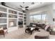 Bright living room with tile floors, built-in shelving, large windows with backyard views, and comfortable seating at 2415 W Hazelhurst Ct, Anthem, AZ 85086