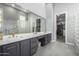 Elegant bathroom featuring marble counters, double vanity, modern fixtures, and a glass block wall shower at 2415 W Hazelhurst Ct, Anthem, AZ 85086