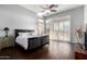 Bright main bedroom boasts dark wood floors, a ceiling fan, and French doors to the backyard at 2415 W Hazelhurst Ct, Anthem, AZ 85086