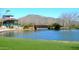 Scenic pond and bridge surrounded by lush landscaping, mountains, and community buildings at 2415 W Hazelhurst Ct, Anthem, AZ 85086