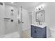 Modern bathroom featuring a walk-in shower with marble tiling and a blue vanity with elegant fixtures at 2425 E Harvard St, Phoenix, AZ 85008