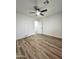 Bright bedroom featuring wood-look floors, ceiling fan, and fresh white paint at 2425 E Harvard St, Phoenix, AZ 85008