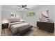 Staged bedroom with wood-look flooring, comfortable bed, ceiling fan, and decorative accents at 2425 E Harvard St, Phoenix, AZ 85008