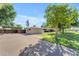 Property with a long driveway, lush lawn, mature tree, and a one-story stucco house with modern design at 2425 E Harvard St, Phoenix, AZ 85008