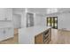 Modern kitchen featuring a quartz island, stainless appliances, white cabinets, and wood-look flooring at 2425 E Harvard St, Phoenix, AZ 85008