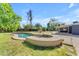 Beautifully landscaped backyard featuring a custom-shaped pool and spa, surrounded by lush greenery at 2425 E Harvard St, Phoenix, AZ 85008