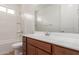 Bathroom features a white vanity with ample countertop space, a shower-tub combo, and a large mirror at 25215 N 131St Dr, Peoria, AZ 85383