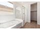 Modern bathroom featuring a soaking tub and glass-enclosed shower at 25215 N 131St Dr, Peoria, AZ 85383