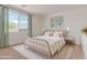Serene bedroom with a large window, stylish decor, and a comfortable queen-sized bed at 25215 N 131St Dr, Peoria, AZ 85383