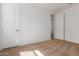 An empty bedroom with neutral carpet, white walls, and two doors creating a serene and adaptable living space at 25215 N 131St Dr, Peoria, AZ 85383