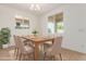 Elegant dining room with ample natural light, modern chandelier, and comfortable seating for six at 25215 N 131St Dr, Peoria, AZ 85383