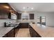 Elegant kitchen with stainless steel appliances, granite countertops, dark cabinets, and a view of the outdoors at 25248 W Chanute Pass, Buckeye, AZ 85326