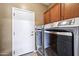 Laundry room with modern washer and dryer, cabinet storage and access to the exterior at 2727 S Equestrian Dr # 103, Gilbert, AZ 85295