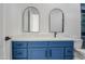 Bathroom featuring blue cabinets, white countertop, and dual modern mirrors at 30634 W Latham St, Buckeye, AZ 85326