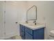 Bathroom featuring blue cabinets, dual sinks, modern mirror, and tile floors at 30634 W Latham St, Buckeye, AZ 85326