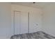Bright bedroom featuring gray flooring, white walls, closet and adjoining door at 30634 W Latham St, Buckeye, AZ 85326