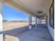 A covered patio with ceiling fans looks out onto a dirt lot and other houses in the distance at 30634 W Latham St, Buckeye, AZ 85326