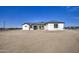 An eye-level shot of a bright, white single-story home with black trim and a desert landscape in the front yard at 30634 W Latham St, Buckeye, AZ 85326