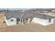 A charming single-story home with a gray tiled roof sits on a large lot ready for landscaping at 30634 W Latham St, Buckeye, AZ 85326