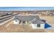 A charming single-story home with a gray tiled roof sits on a large lot ready for landscaping at 30634 W Latham St, Buckeye, AZ 85326