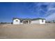 A bright white single-story home with a gray roof surrounded by a dirt lot at 30634 W Latham St, Buckeye, AZ 85326