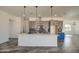 Open kitchen featuring a large island, stylish pendants, and gray cabinets at 30634 W Latham St, Buckeye, AZ 85326