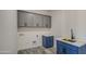 Well lit laundry room featuring gray upper cabinets and blue lower cabinets at 30634 W Latham St, Buckeye, AZ 85326