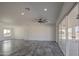 Open living space with gray tiled floors, fan and sliding glass doors at 30634 W Latham St, Buckeye, AZ 85326