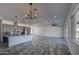 Open floor plan of the kitchen and living room, featuring tile floors, gray kitchen cabinets, and lots of light at 30634 W Latham St, Buckeye, AZ 85326