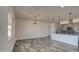 The living room and kitchen space features tile floors, modern light fixtures, and a large window providing ample lighting at 30634 W Latham St, Buckeye, AZ 85326