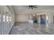 A spacious, open-concept living room that integrates a kitchen with gray cabinets, creating a harmonious living space at 30634 W Latham St, Buckeye, AZ 85326