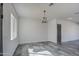 Bright living room features a modern chandelier and gray tiled floors at 30634 W Latham St, Buckeye, AZ 85326
