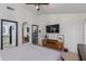 Spacious bedroom with a TV, console table, and an arched mirror reflecting the en-suite bathroom at 4044 E Cascalote Dr, Cave Creek, AZ 85331