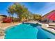 Sparkling backyard pool with desert landscaping, lounge chairs and mature trees providing shade at 4044 E Cascalote Dr, Cave Creek, AZ 85331