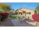 Landscaped backyard featuring a stone patio, artificial grass, and vibrant foliage, perfect for outdoor dining and relaxation at 4841 E Kirkland Rd, Phoenix, AZ 85054