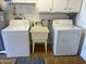 Bright laundry room with a washer, dryer, utility sink, white cabinets, and wood-look flooring at 6224 E Decatur St, Mesa, AZ 85205