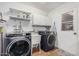 Well-equipped laundry room with modern washer and dryer, utility sink, and storage cabinets at 6224 E Decatur St, Mesa, AZ 85205
