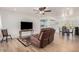 Open-concept living room with hardwood floors, a modern entertainment center, and a seamless flow to the dining area at 6224 E Decatur St, Mesa, AZ 85205