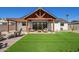 Beautiful backyard featuring a covered patio with modern outdoor furniture and a well-maintained lawn at 7525 E Latham St, Scottsdale, AZ 85257