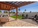 Inviting backyard featuring a covered patio, artificial grass, and a cozy fire pit area at 7525 E Latham St, Scottsdale, AZ 85257