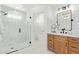 Modern bathroom featuring white tile shower and wood vanity with black fixtures at 7525 E Latham St, Scottsdale, AZ 85257