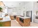 Bright kitchen features custom cabinets, stainless appliances, and an island with bar seating at 7525 E Latham St, Scottsdale, AZ 85257