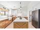 Bright kitchen boasts custom cabinets, stainless appliances, an island, and easy access to the laundry room at 7525 E Latham St, Scottsdale, AZ 85257