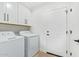 Well-equipped laundry room with white cabinets and modern appliances at 7525 E Latham St, Scottsdale, AZ 85257
